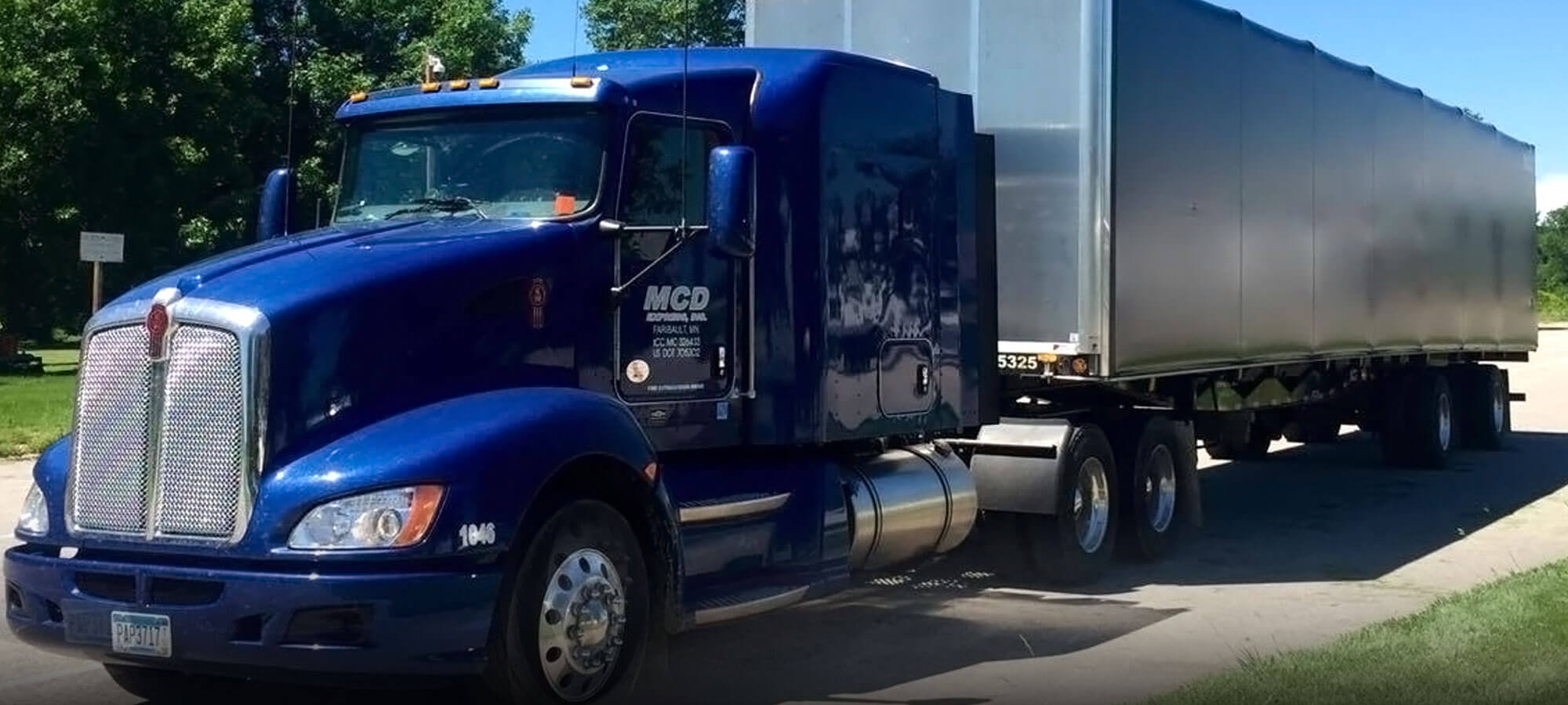 Royal blue MCD Express semi tractor hauling a dry van container